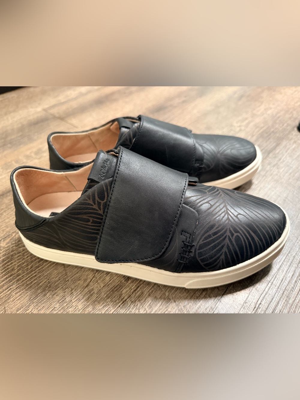 OluKai Pehuea Loupili Black Leather Slip-On Loafers with Subtle Leaf Embossing